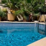 Byhus med terrasser och pool