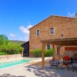 Välrenoverad stenlada med pool och trädgård